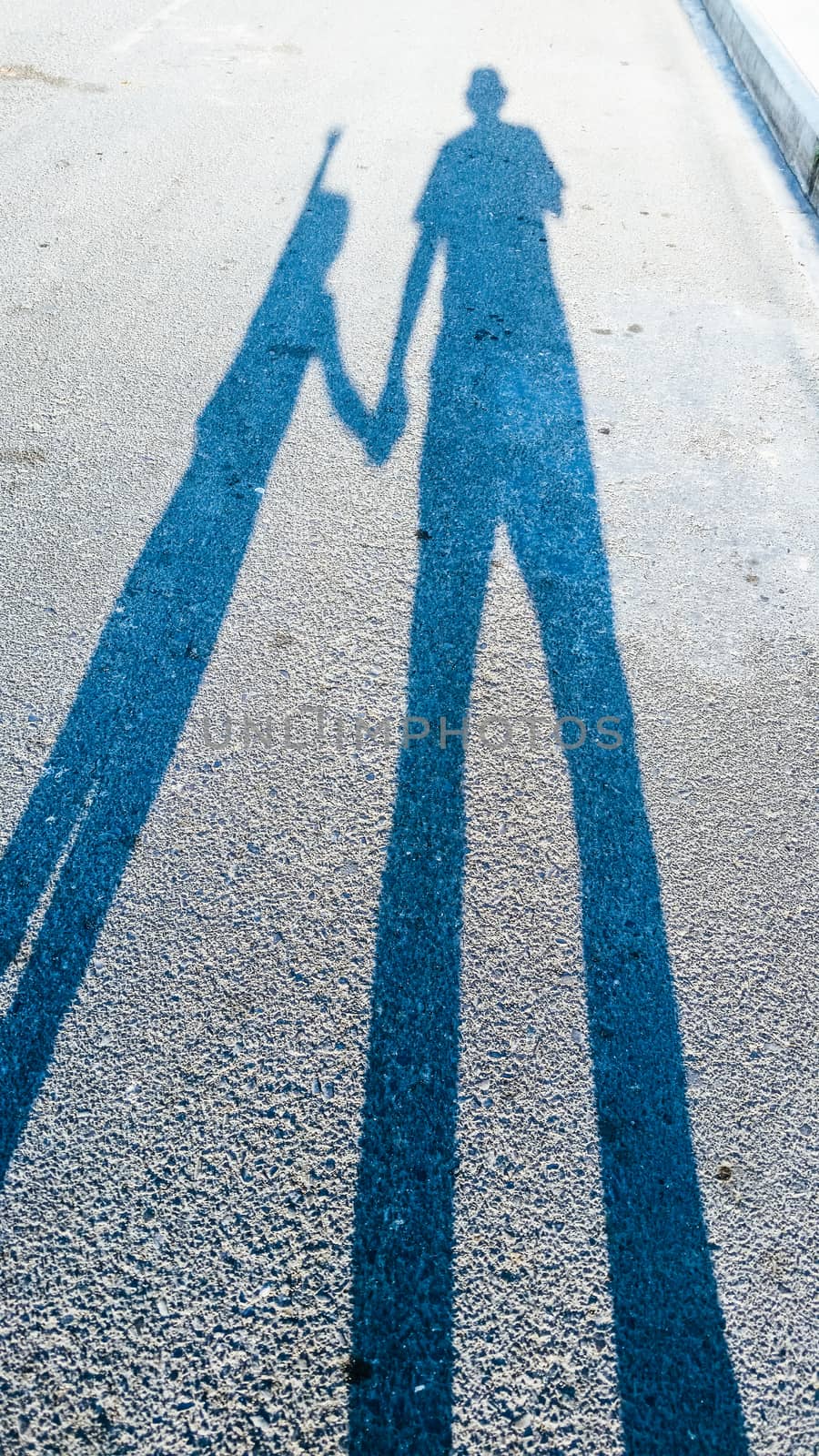 the shadow of an adult and a child on the track.