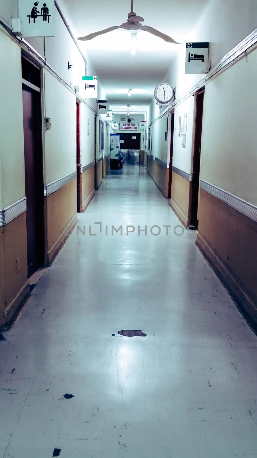 Empty long corridor in the hospital, at the end of the corridor you can read that it says: surgical center.