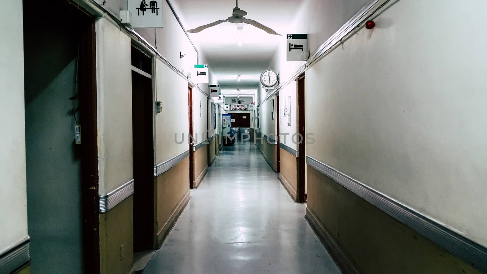 Empty long corridor in the hospital, at the end of the corridor you can read that it says: surgical center.