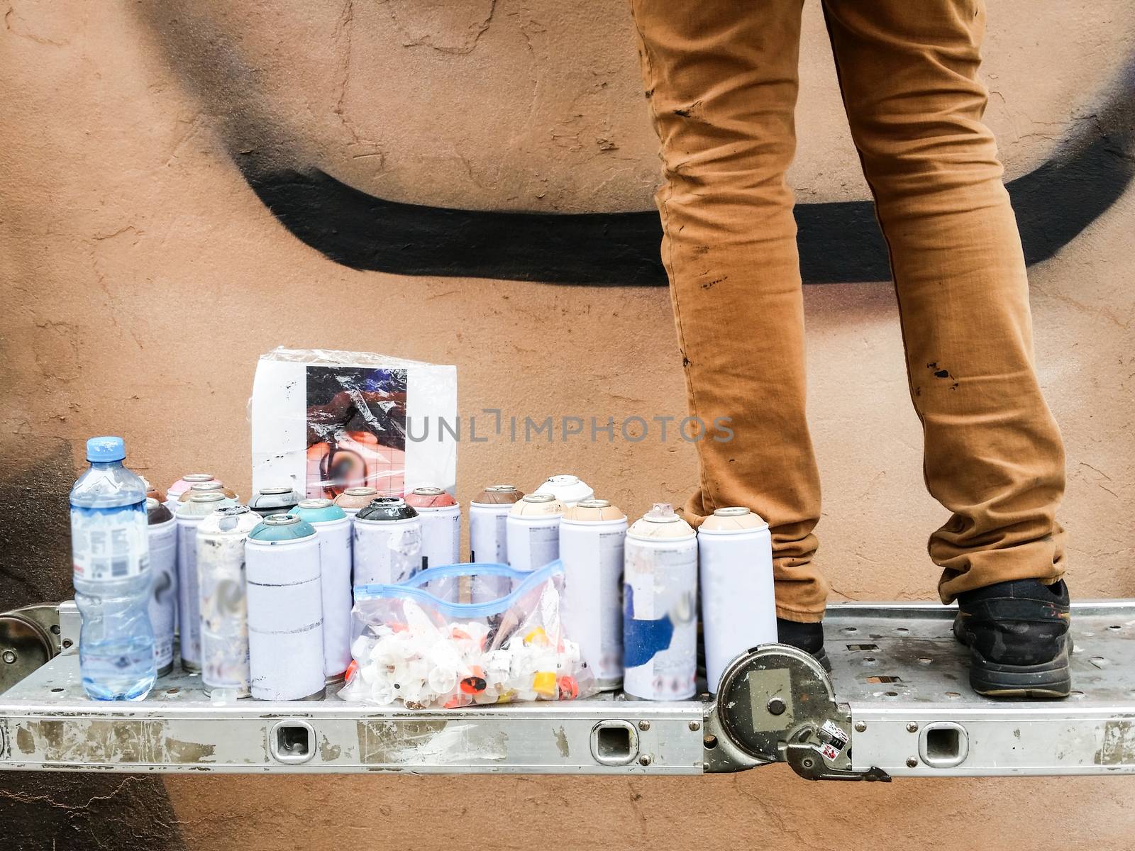 Young urban painter starting to draw graffiti on the wall