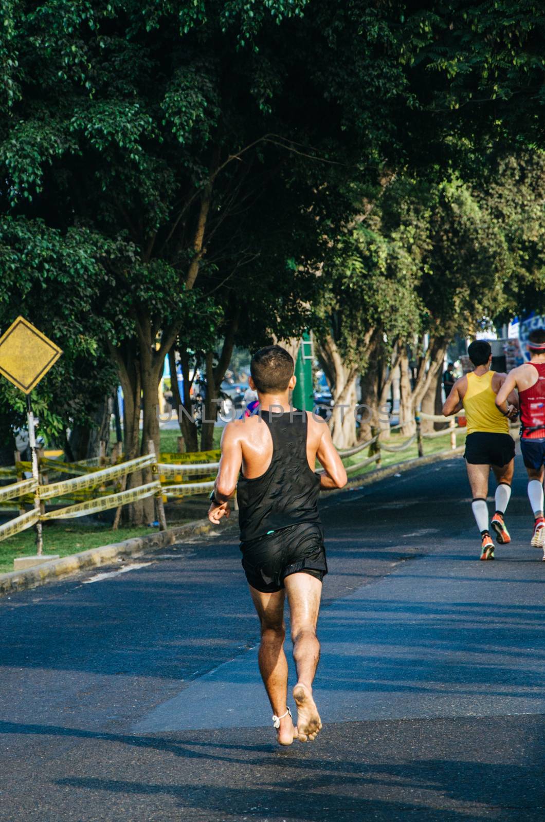 Barefoot runner on the street track in the marathon