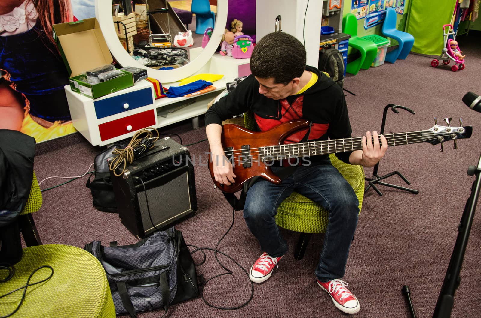 Singer Bass guitarist sitting testing his instrument