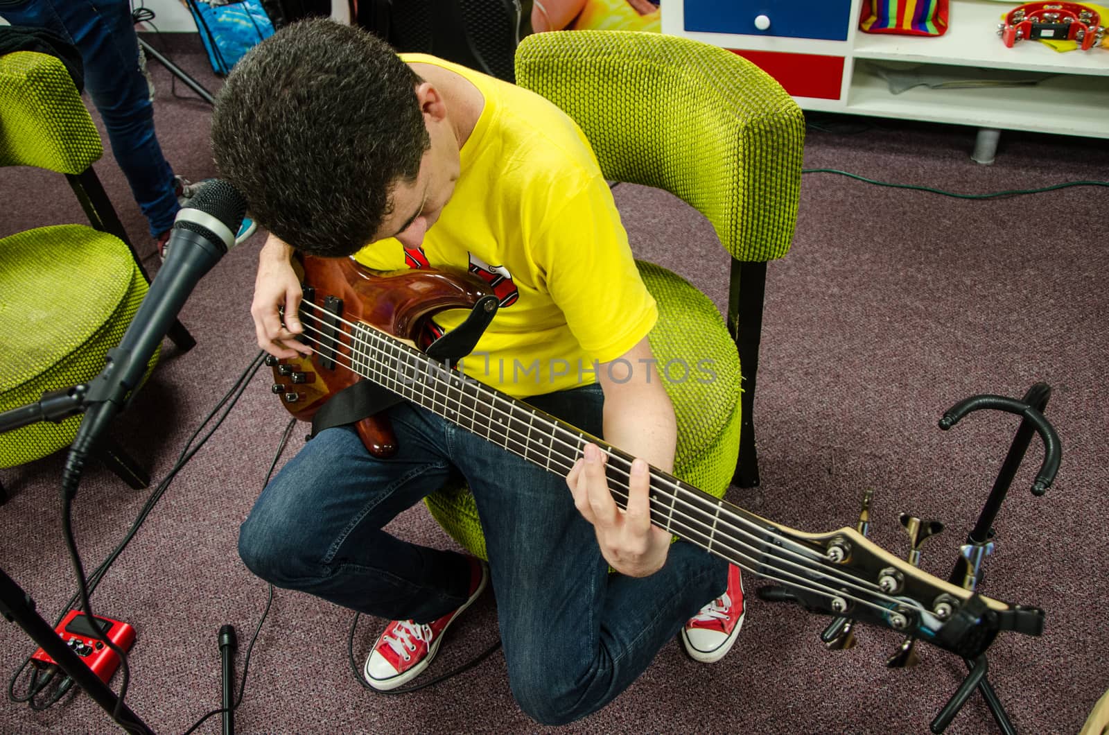 Singer Bass guitarist sitting testing his instrument