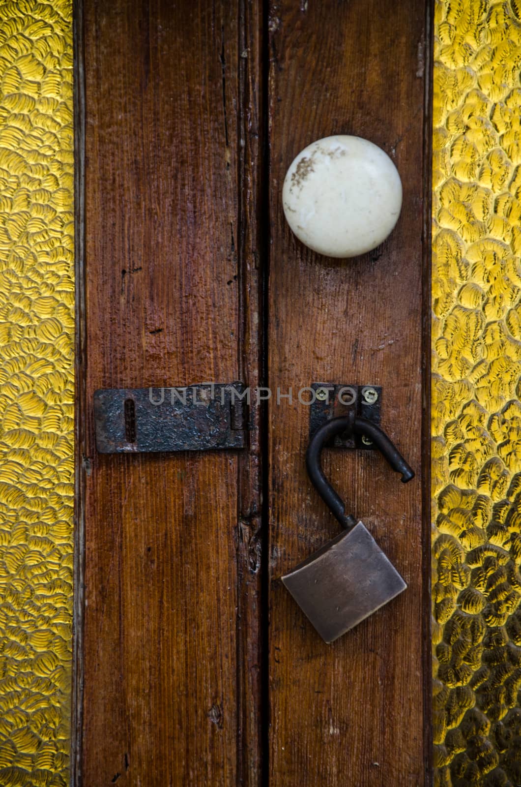 Lock with open padlock of an old wooden door with glass