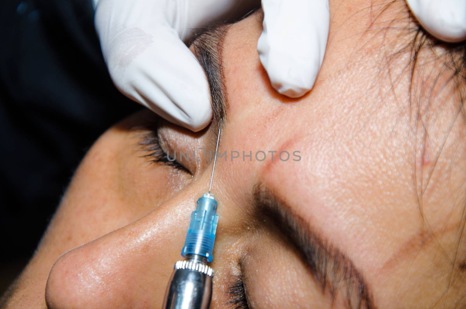 Permanent makeup tattooing of eyebrows. Cosmetologist applying permanent make up on eyebrows - eyebrow tattoo