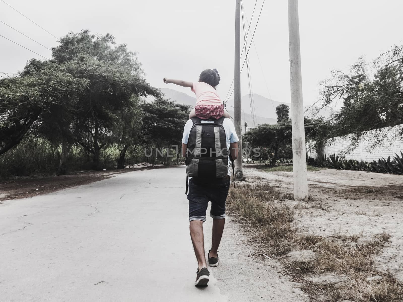 Moment together of father and daughter, the little daughter on the shoulders of dad, walking together