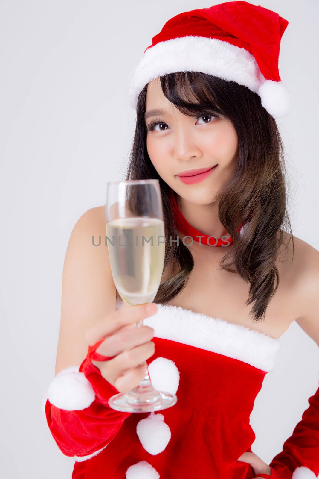 Beautiful portrait young asian woman in Santa holding glass of champagne with party celebrating in xmas holiday isolated on white background, asia girl drink beverage, Christmas and new year concept.