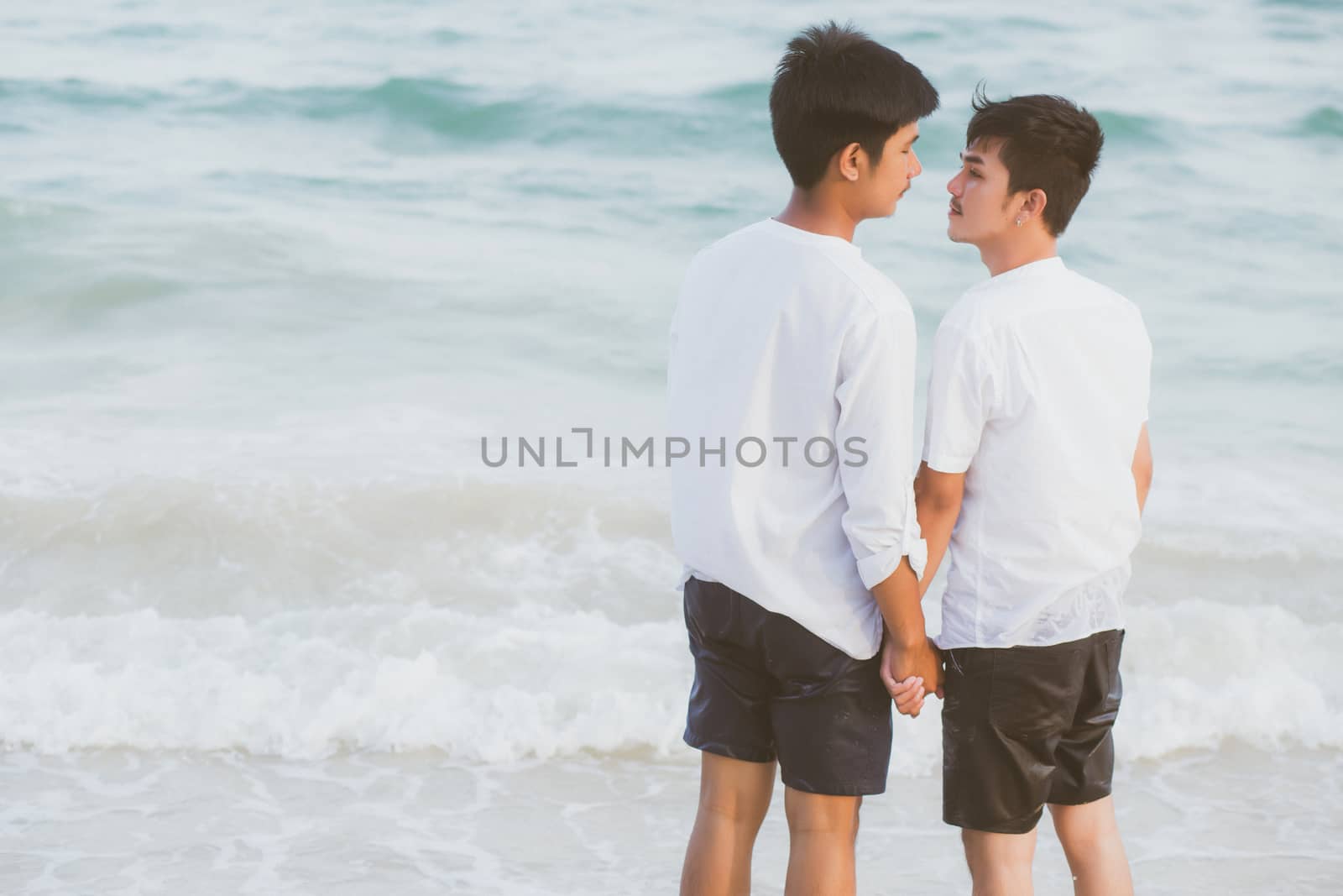 Back view homosexual young asian couple standing together on bea by nnudoo