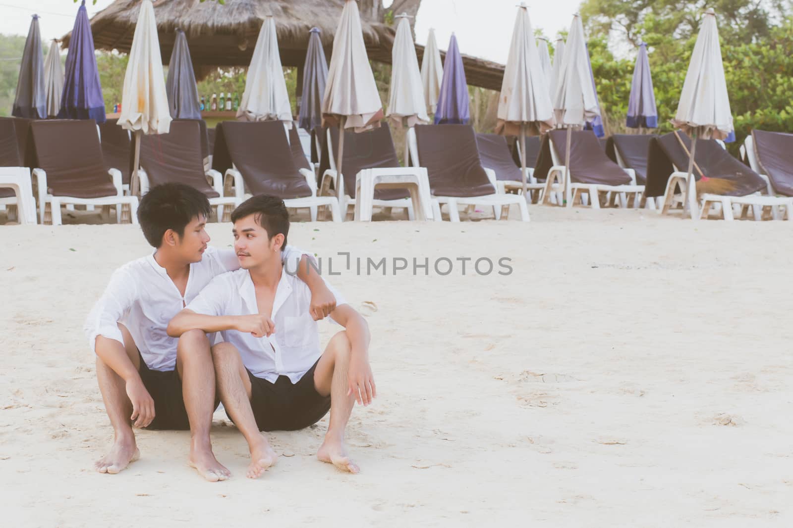 Homosexual portrait young asian couple sitting hug together on b by nnudoo