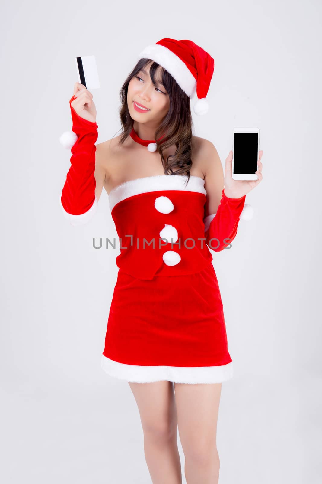 Beautiful portrait young asian woman in Santa shopping for credit card with smart mobile phone in Christmas holiday isolated on white background, beauty asia girl buying gift in xmas day or new year.