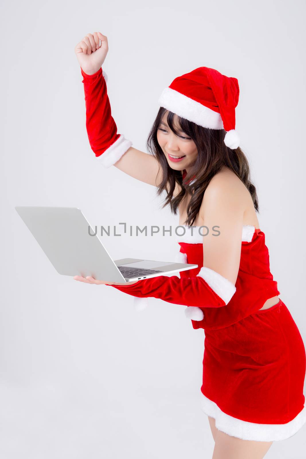 beautiful young asian woman in Santa using working laptop computer in Christmas holiday isolated on white background, presenting asia girl holding showing notebook and success in xmas day.