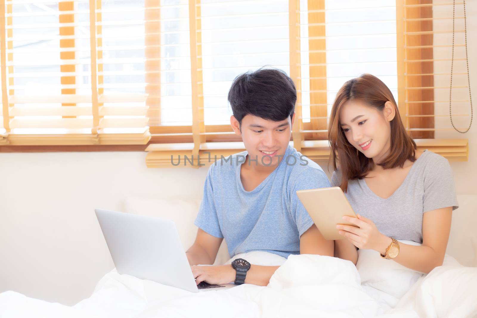 Beautiful young asian couple cheerful freelance working with man by nnudoo