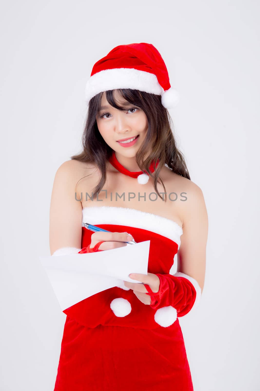 Beautiful portrait young asian woman writing notepad in xmas day isolated on white background, beauty asia girl writing list shopping or wish with excited for celebrating in Christmas holiday.