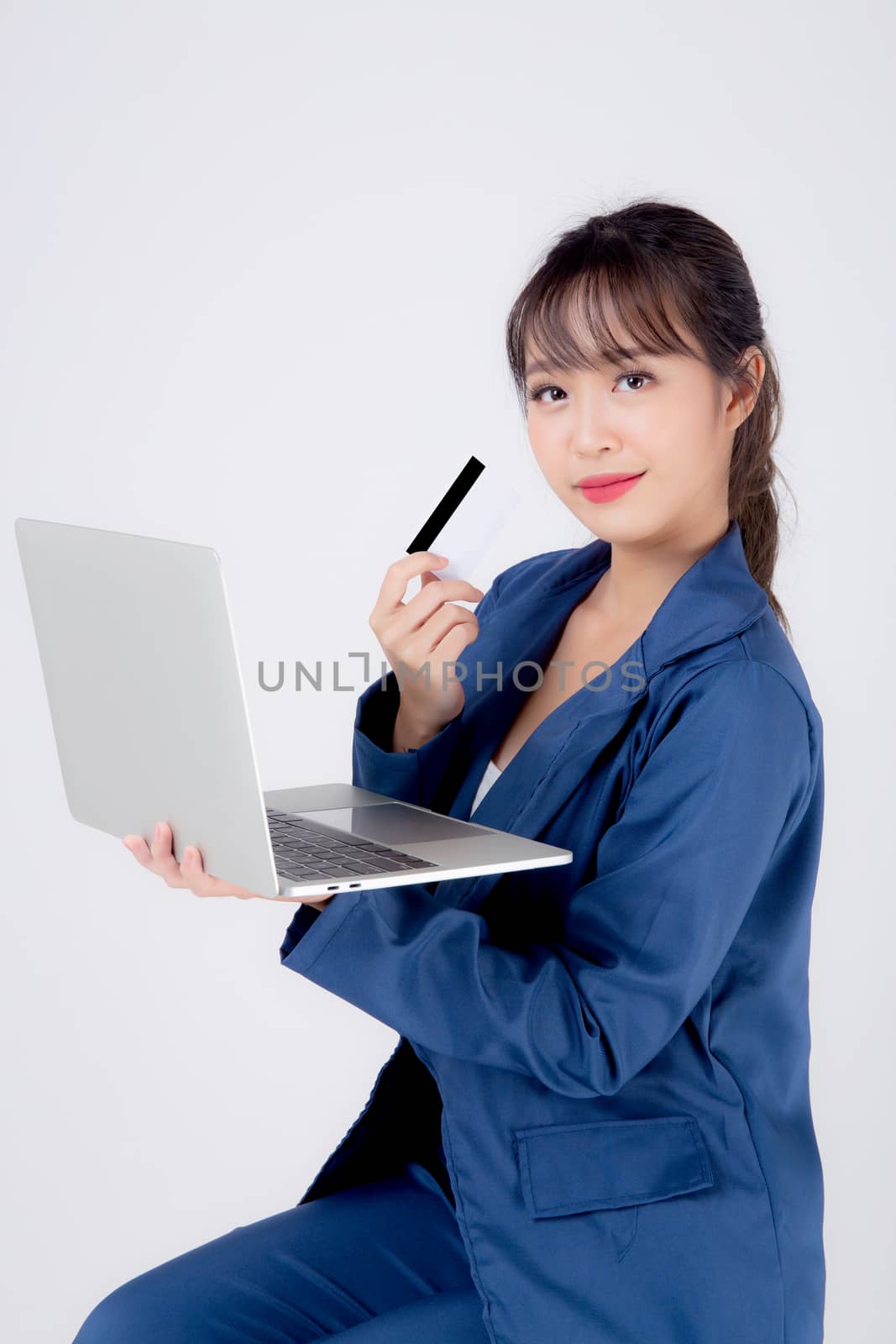 Beautiful young asian business woman happy holding credit card and laptop computer with payment shopping online isolated on white background, businesswoman confident with cash back after using credit.