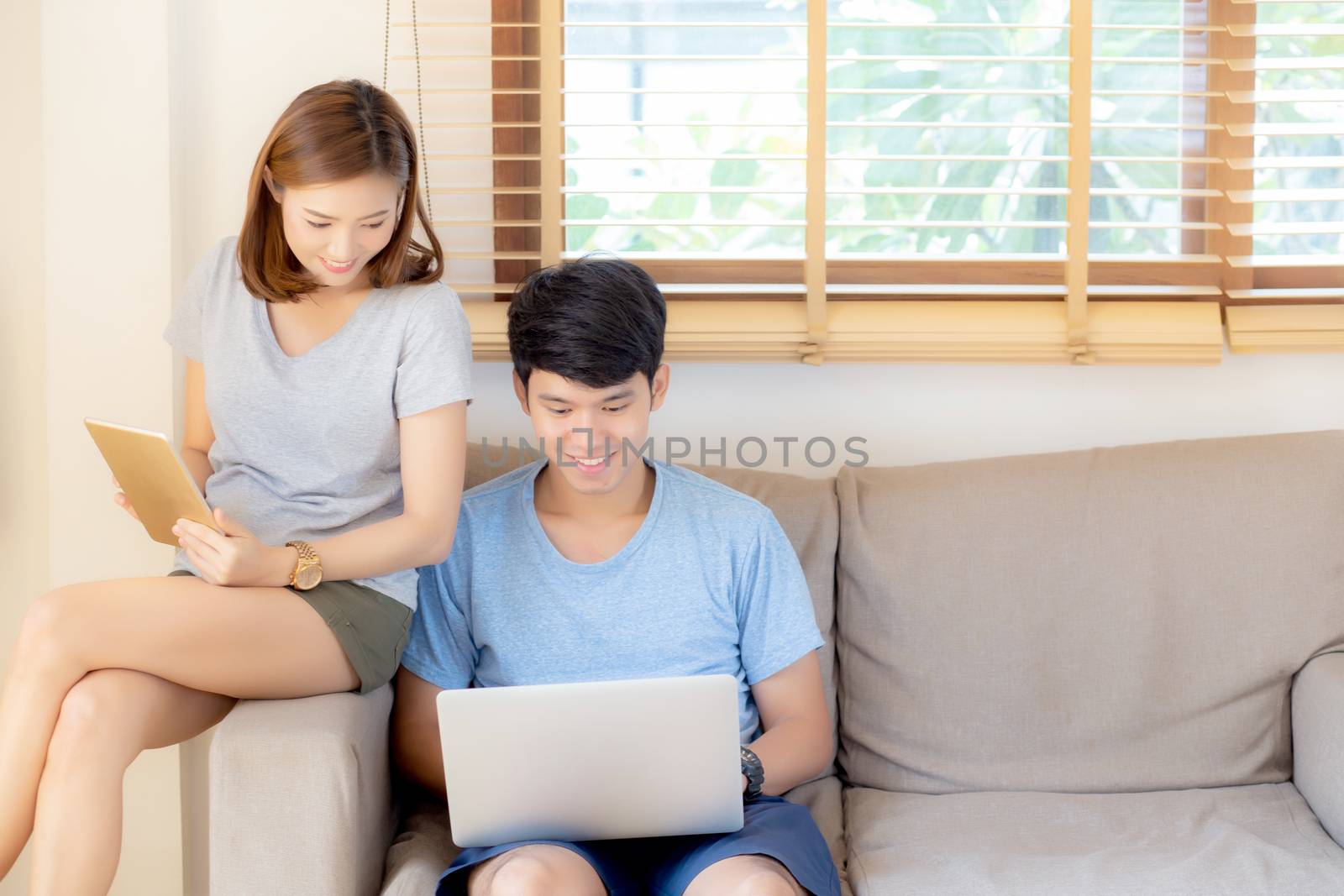 Beautiful young asian couple cheerful freelance working with man by nnudoo