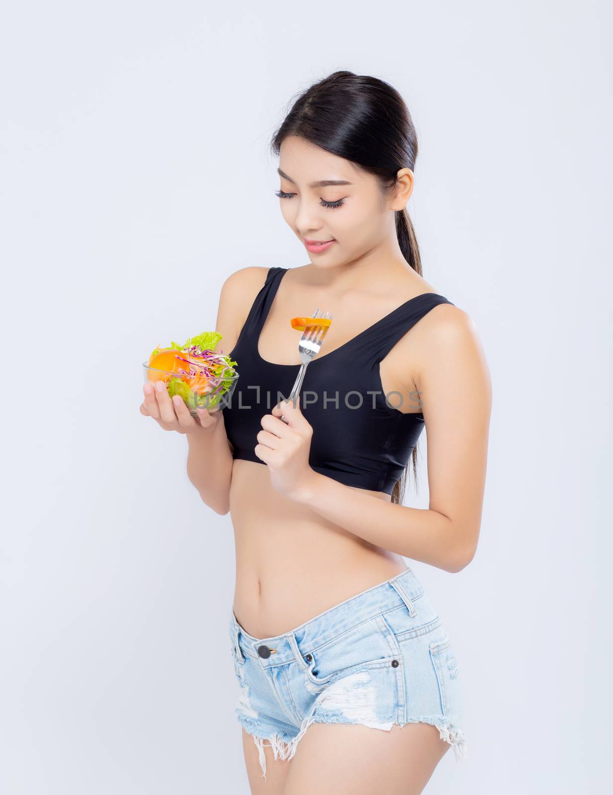 Beautiful portrait young asian woman smiling holding salad vegetable food isolated on white background, girl diet eating vegetarian for healthy, health care or wellness concept.