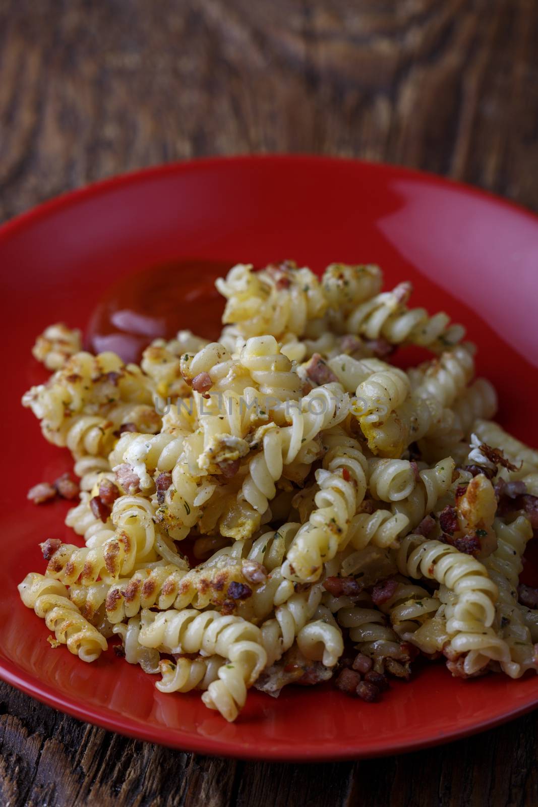 spirelli pasta on a red plate