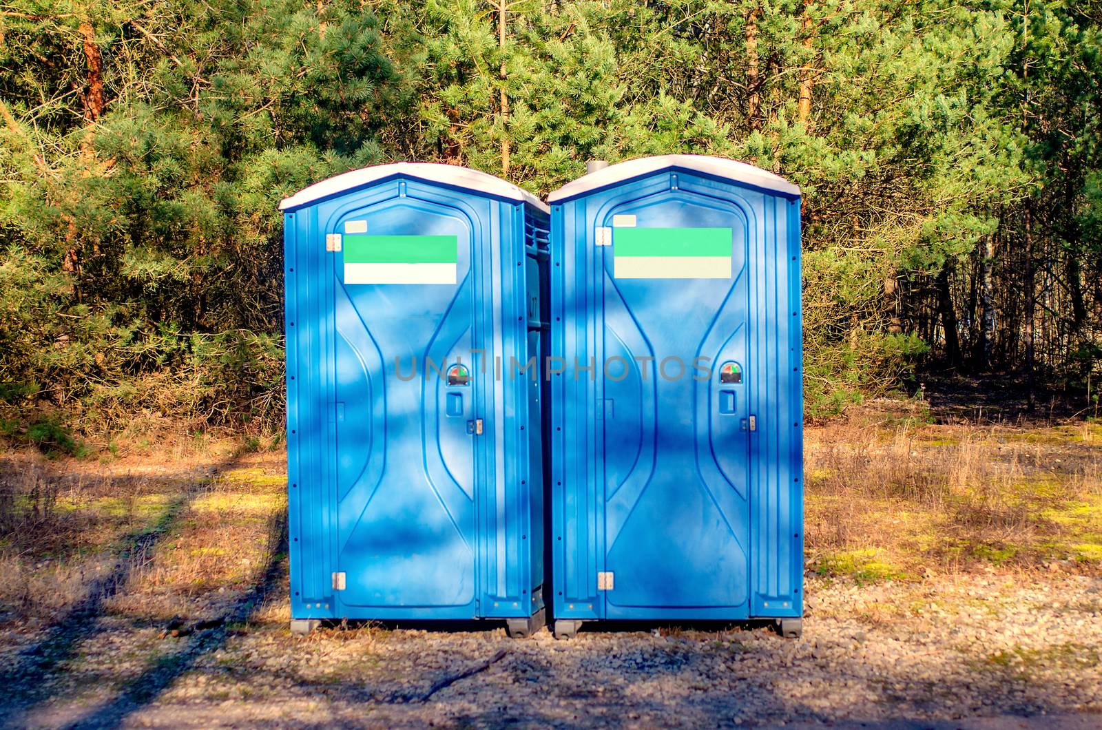 Two blue plastic toilet cabins. Public toilet in the city park. by KajaNi