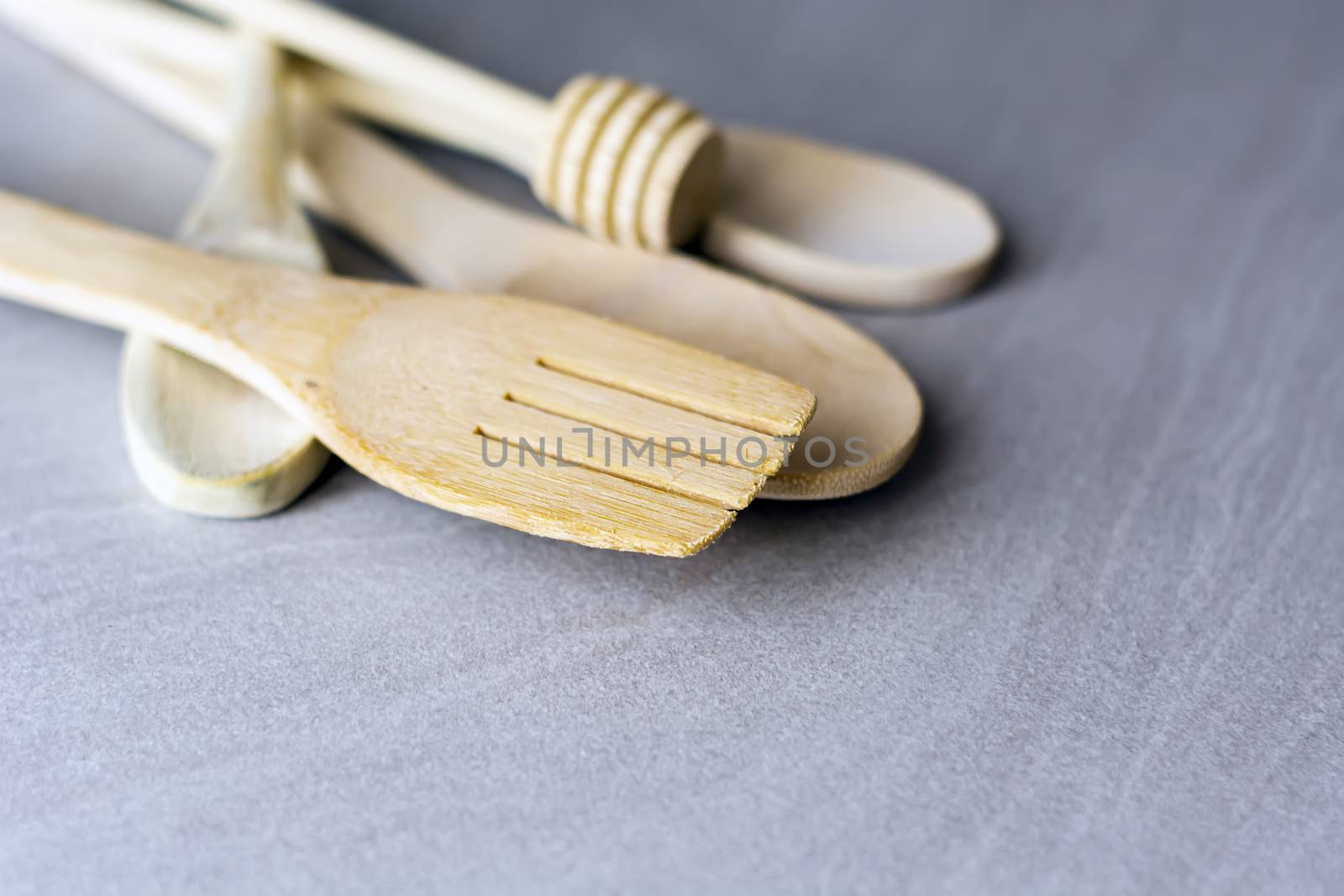 Group of wooden kitchen utensils arranged on a gray marble table by rarrarorro