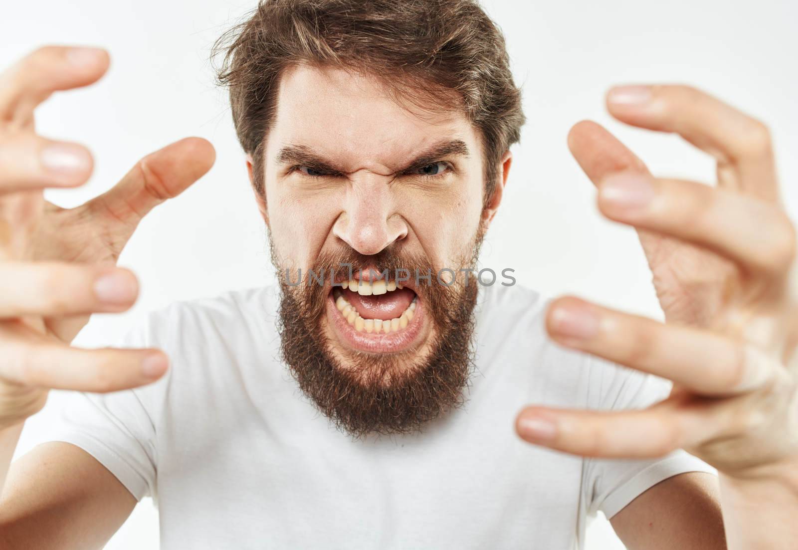 A young man in a white T-shirt gestures with his hands emotions irritability stress. High quality photo