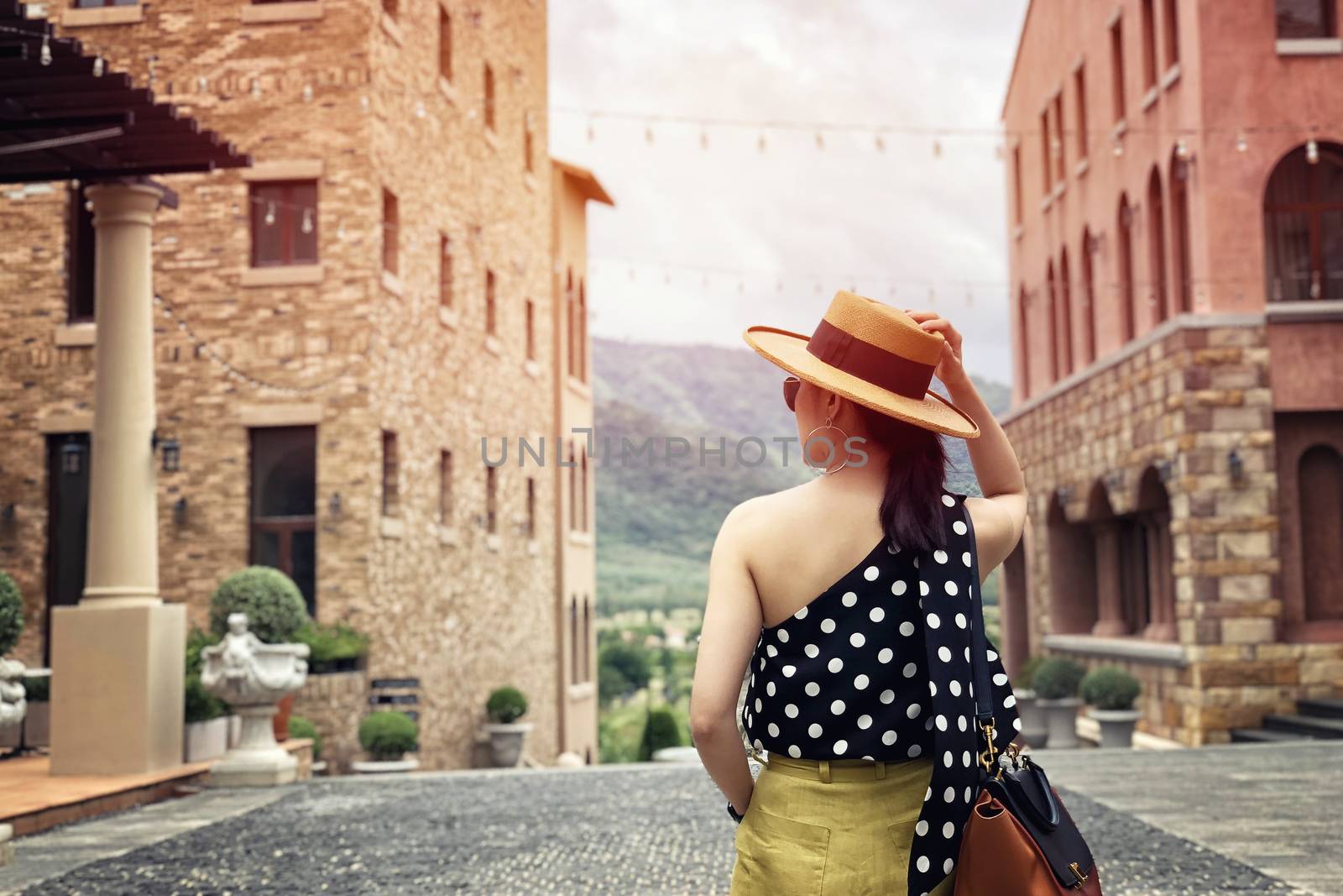 Woman wearing a planter panama hat visiting an Italian style village in summer