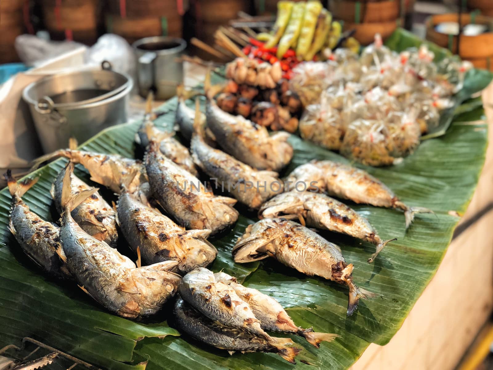 Fried mackerels on banana leaf Thai style bamboo basket for sell in street market.
