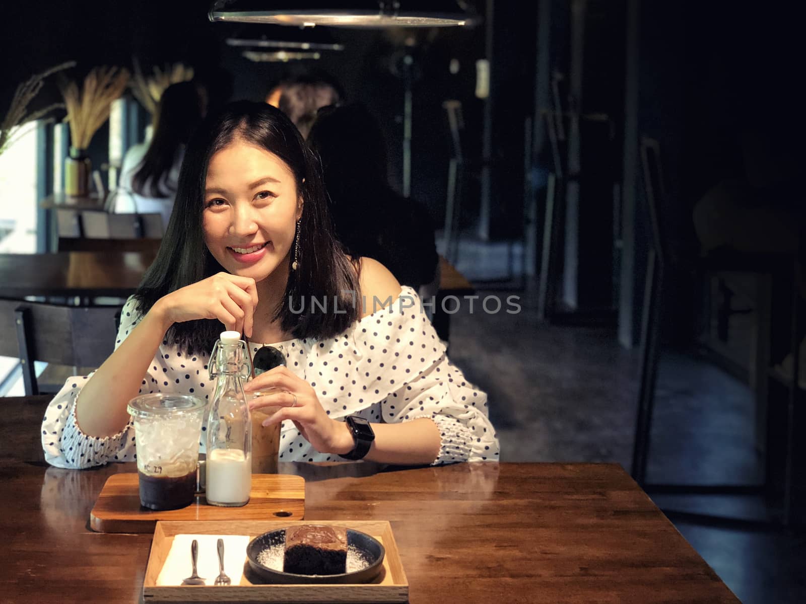 Woman drinking coffee in a cafe by Surasak