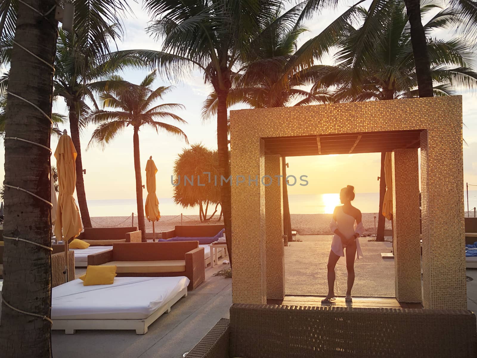 Happiness woman on beach. She is enjoying serene ocean nature sunset during travel holidays vacation outdoors. at phuket Thailand 