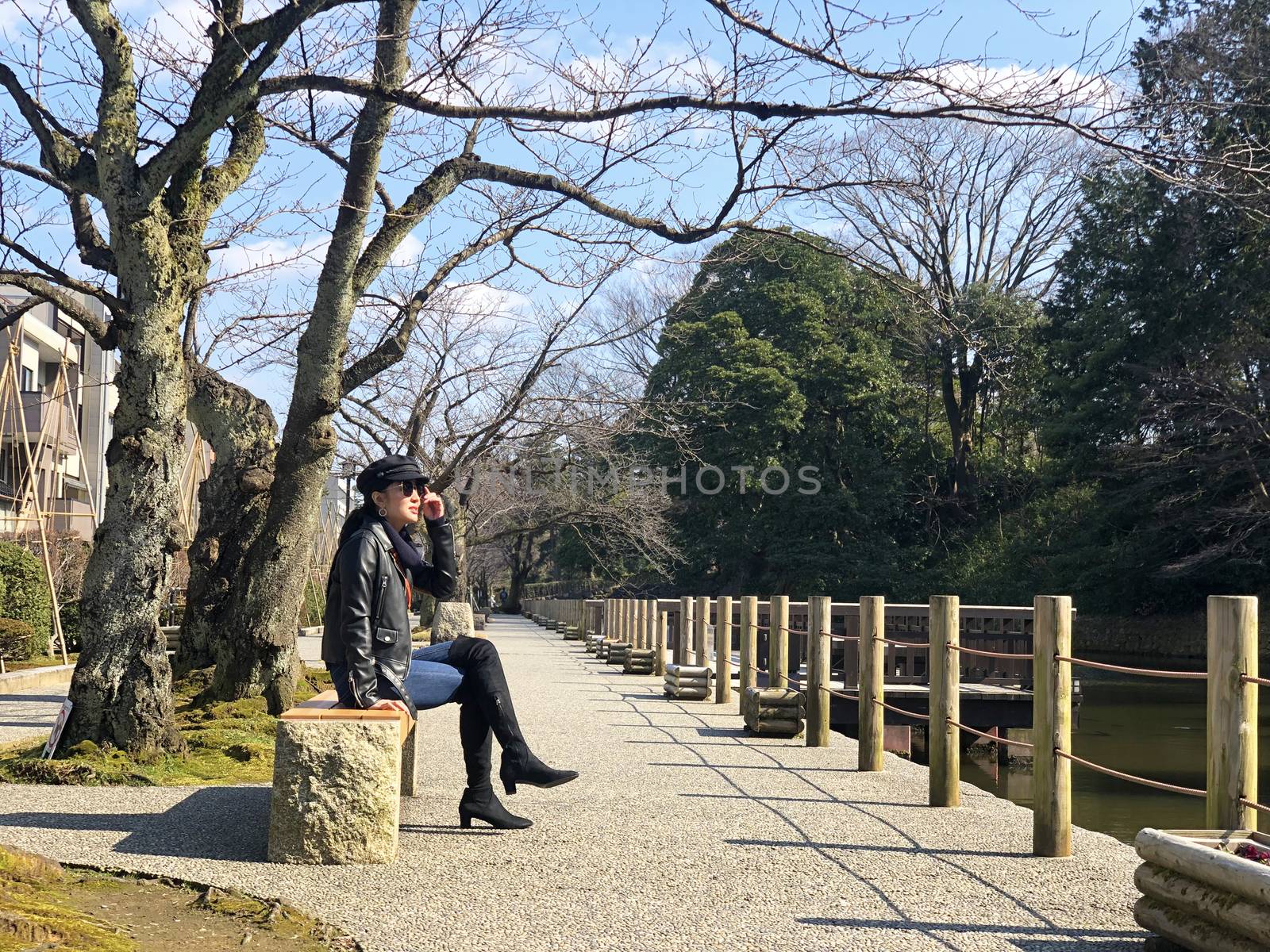 Woman sitting and seeing view around Kenrokuen garden and Kanazawa castle on her relax time.