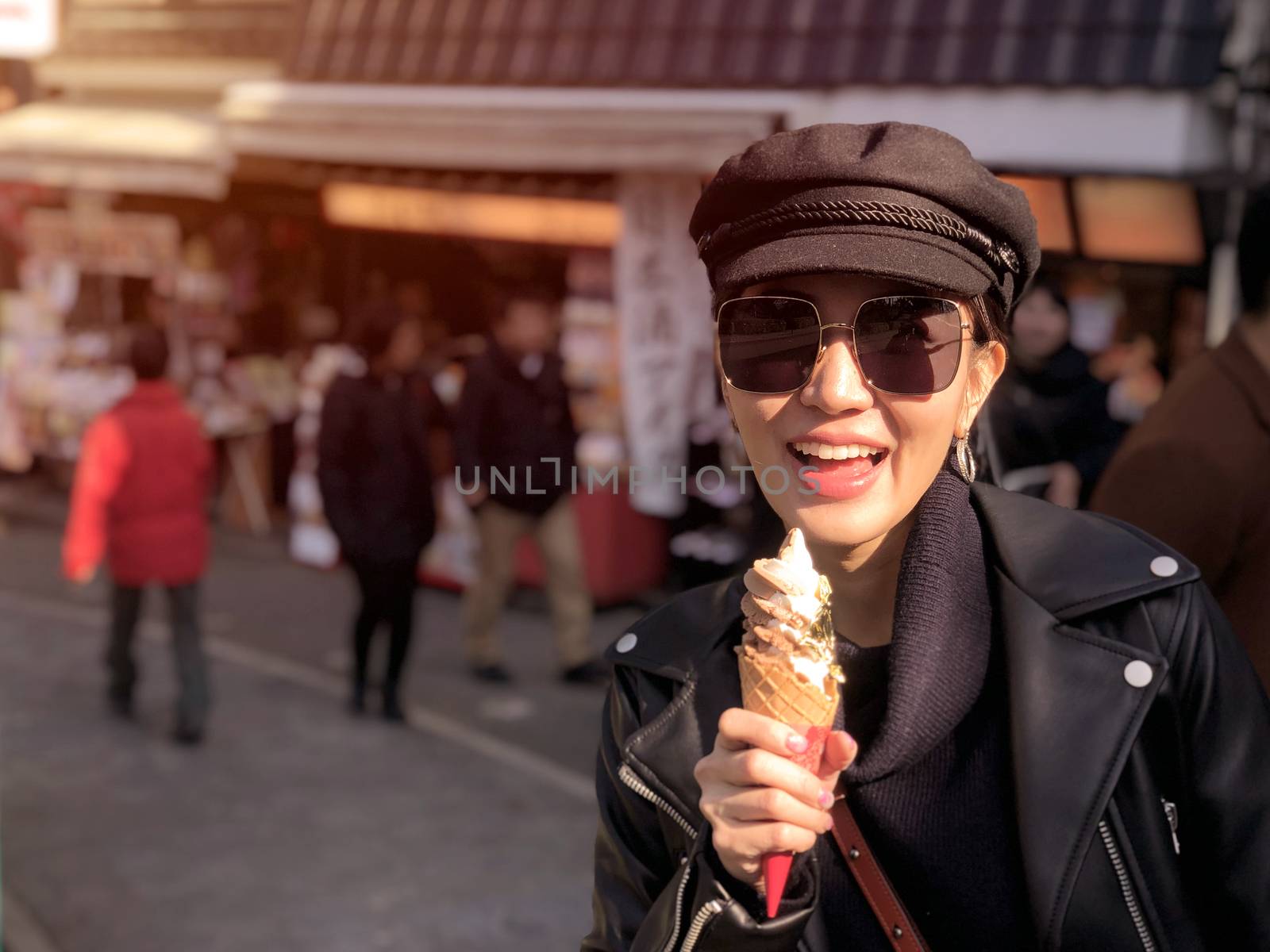 Young tourist woman eating ice cream cone covered with real gold leaf a famous street food in Japan