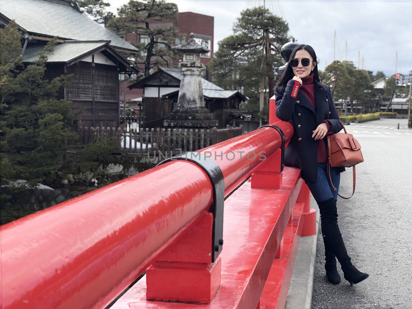 Happy woman tourist enjoy view in Red Nakabashi Bridge of Takaya by Surasak