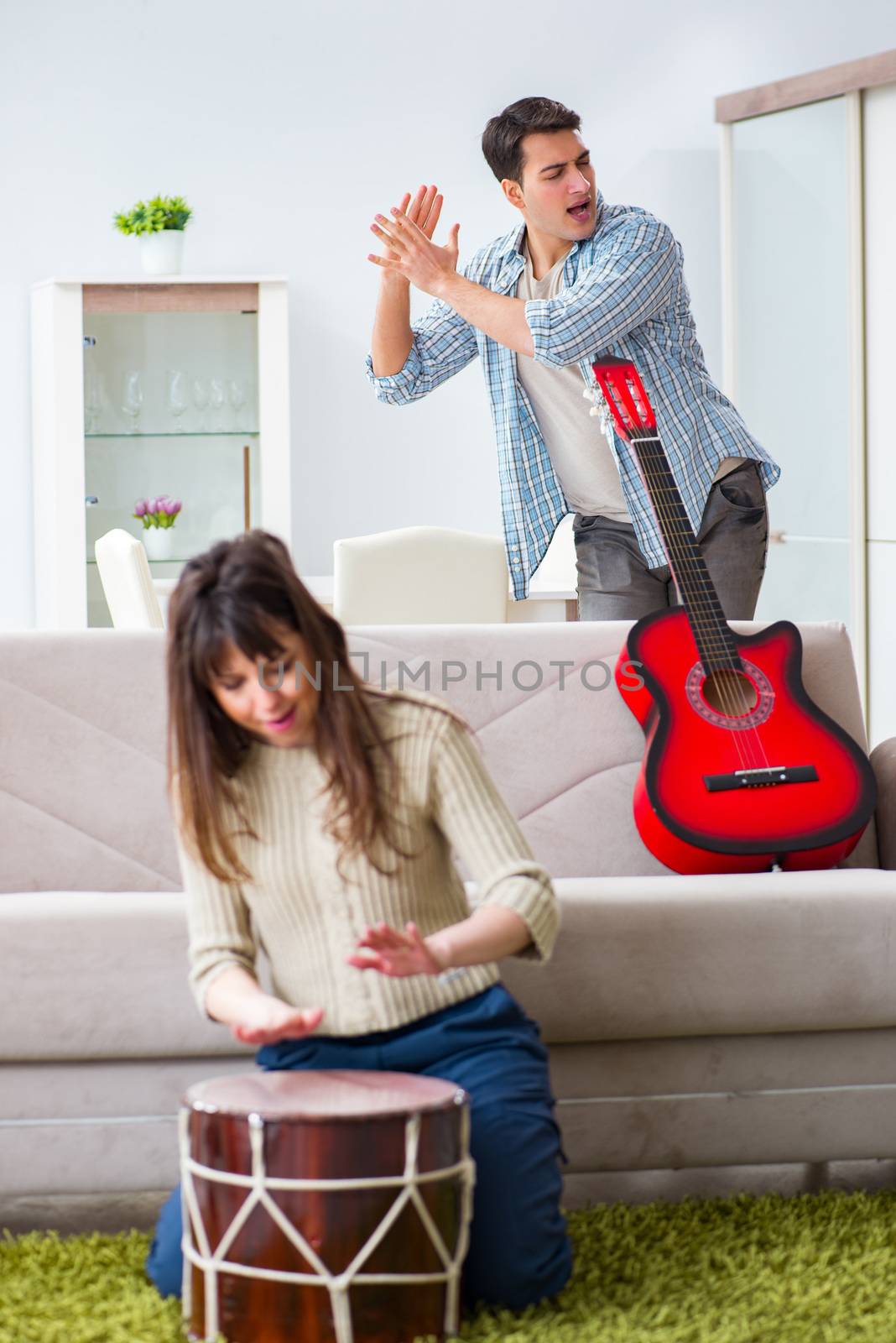 Young family singing and playing music at home