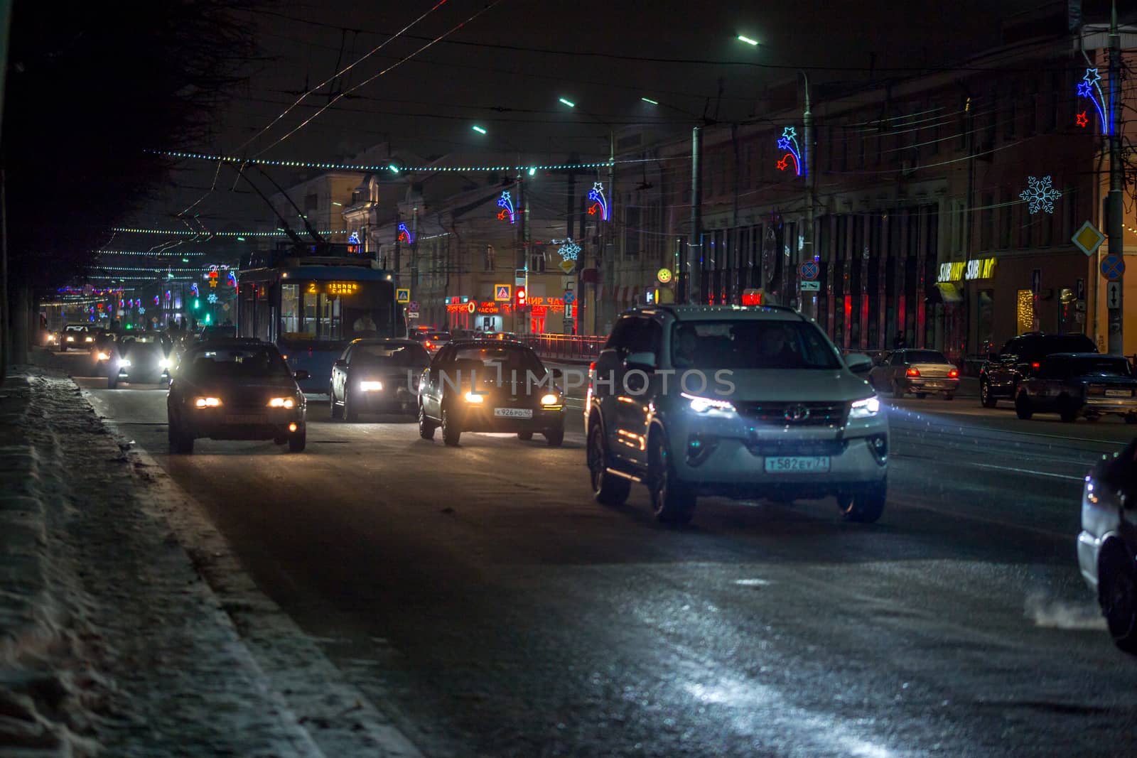 TULA, RUSSIA - JANUARY 01, 2019: Dark night winter traffic on street with night christmas illumination.