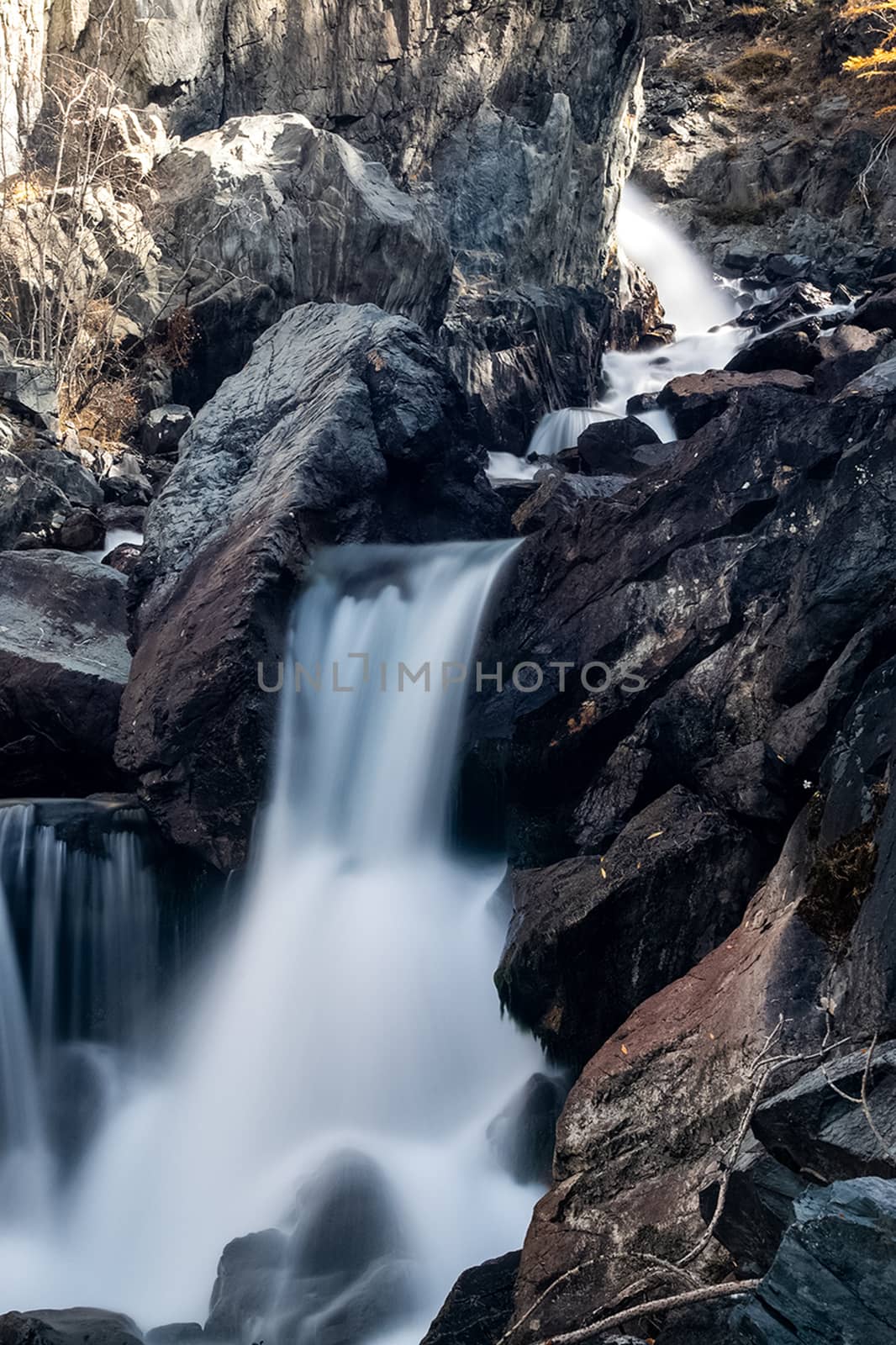 A small waterfall on a mountain river in the Altai. The Altai Mountain Rivers.