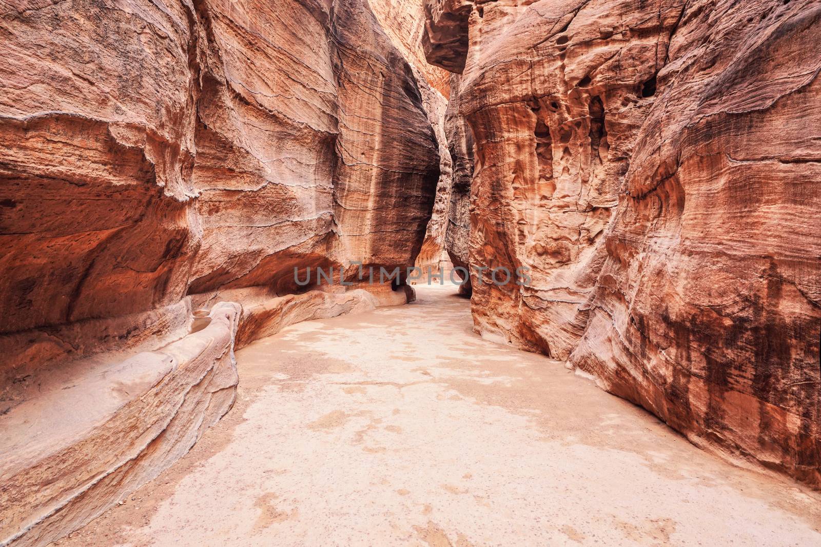 Al Siq Canyon in Petra, Jordan, pink red sandstone walls on both sides.