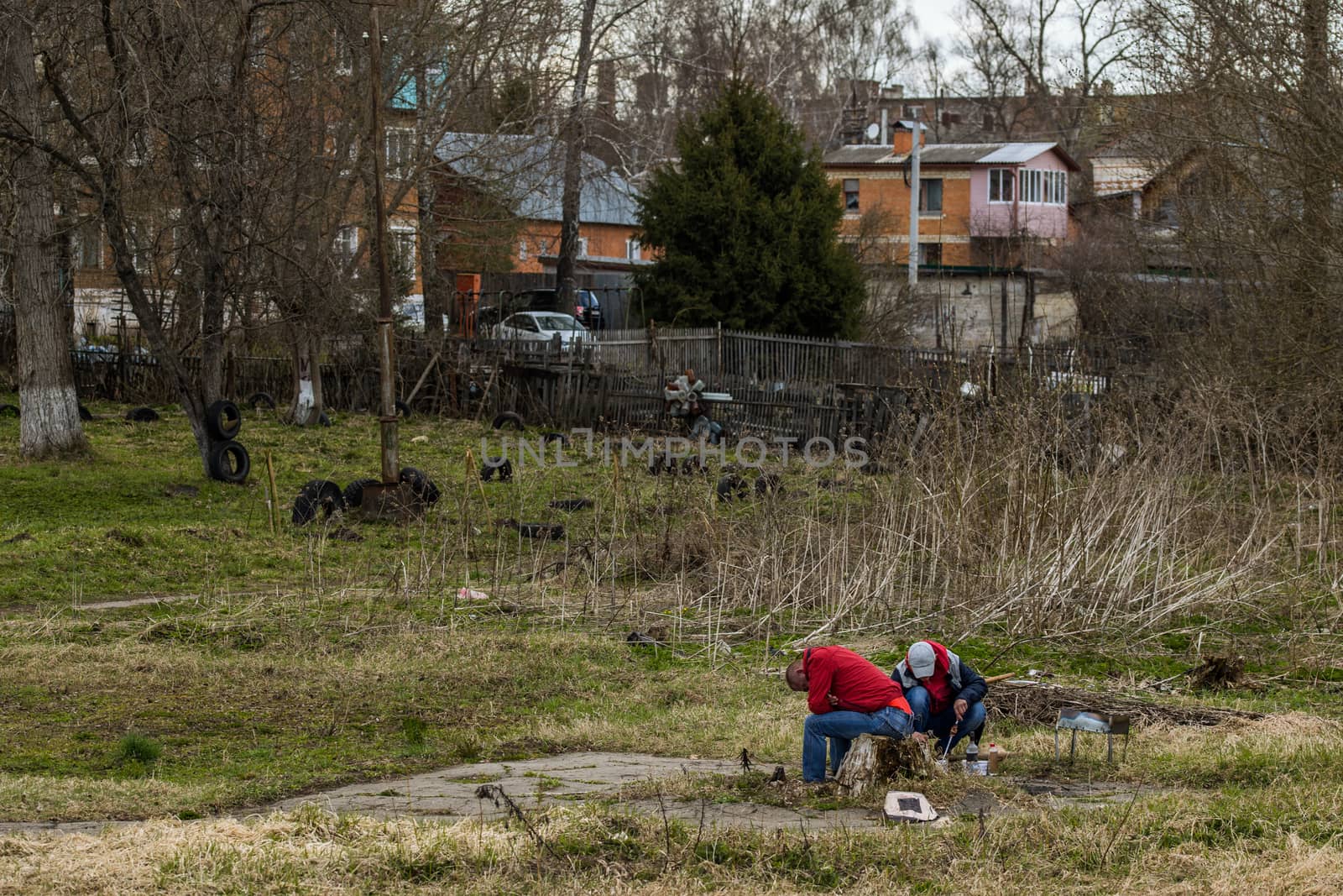 Two russian guys making barbecque in typical place with strong alcohol intoxication view with selective focus.