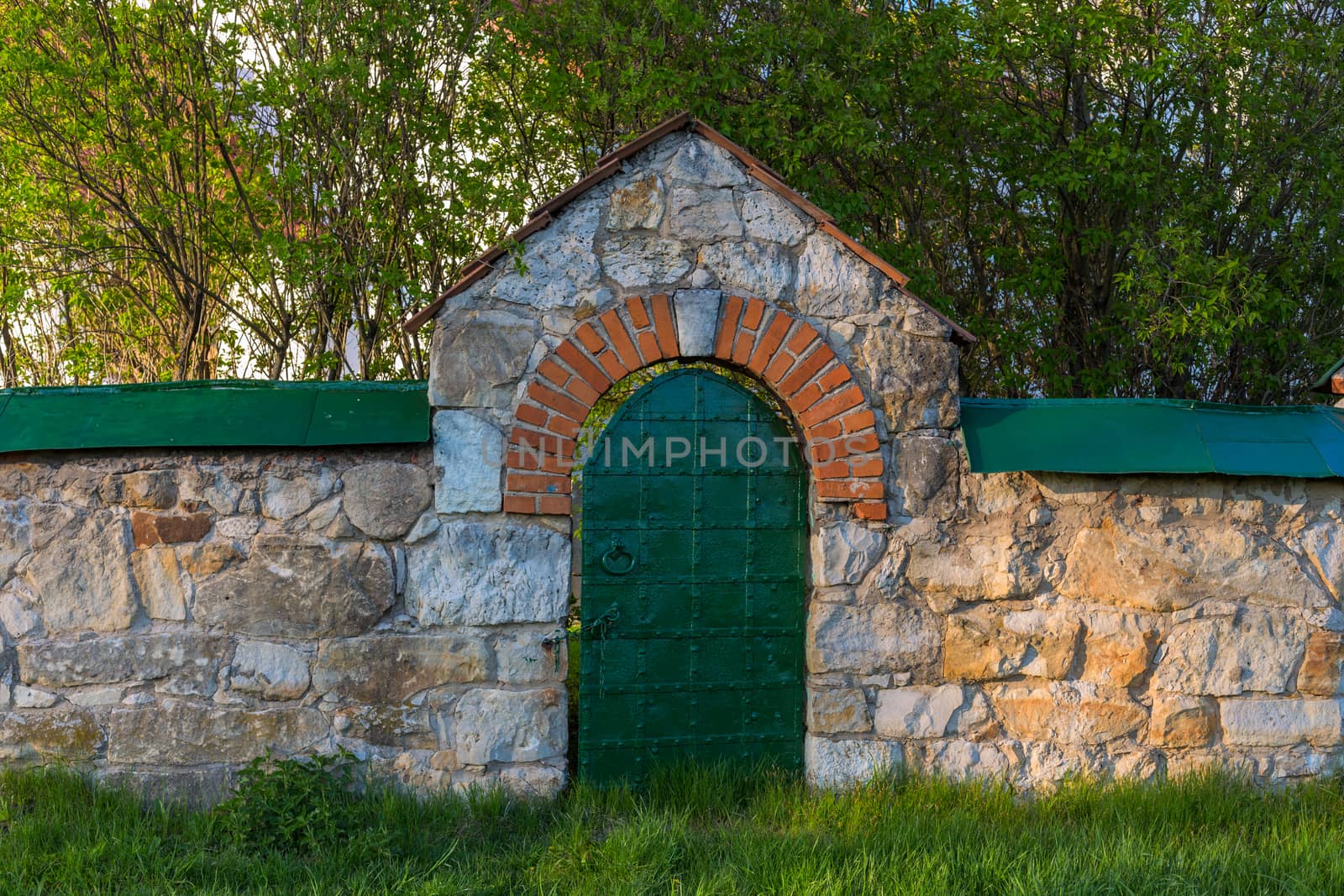 limestone fence with iron riveted wicket at spring evenoing