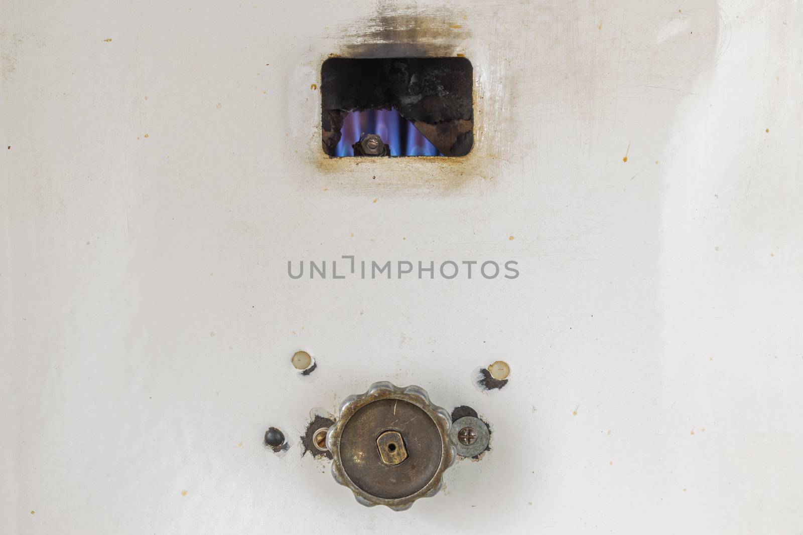 Fired up old russian gas water heater with flat front panel closeup