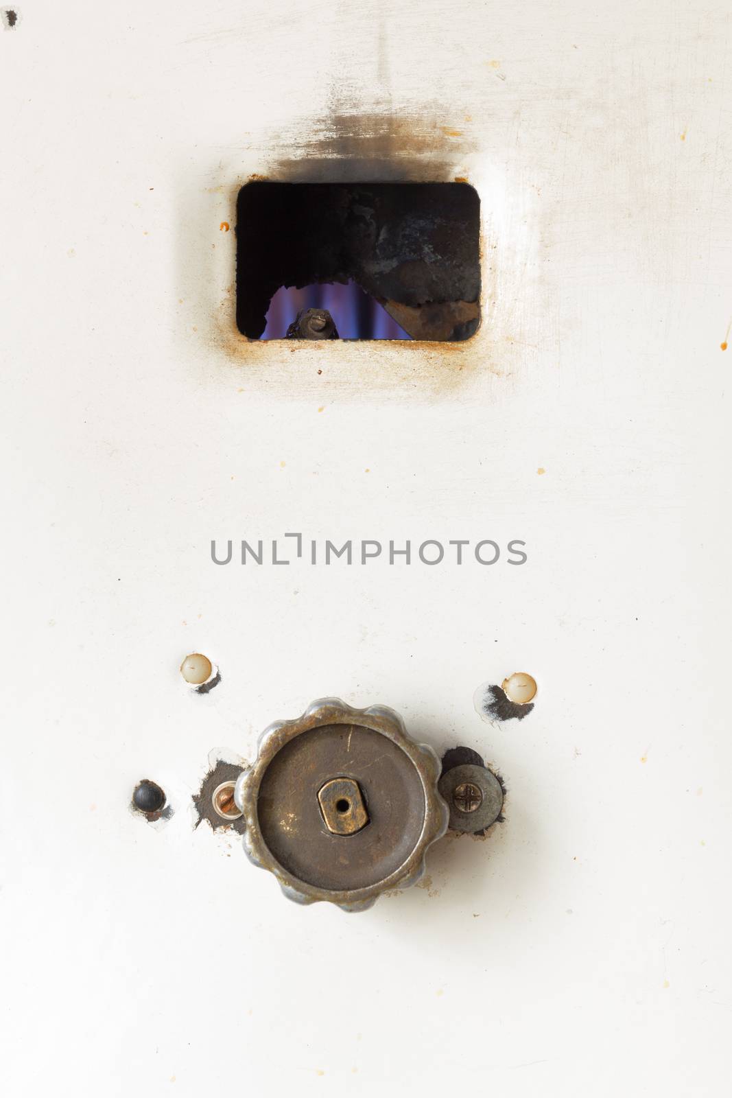 Fired up old russian gas water heater with flat front panel closeup
