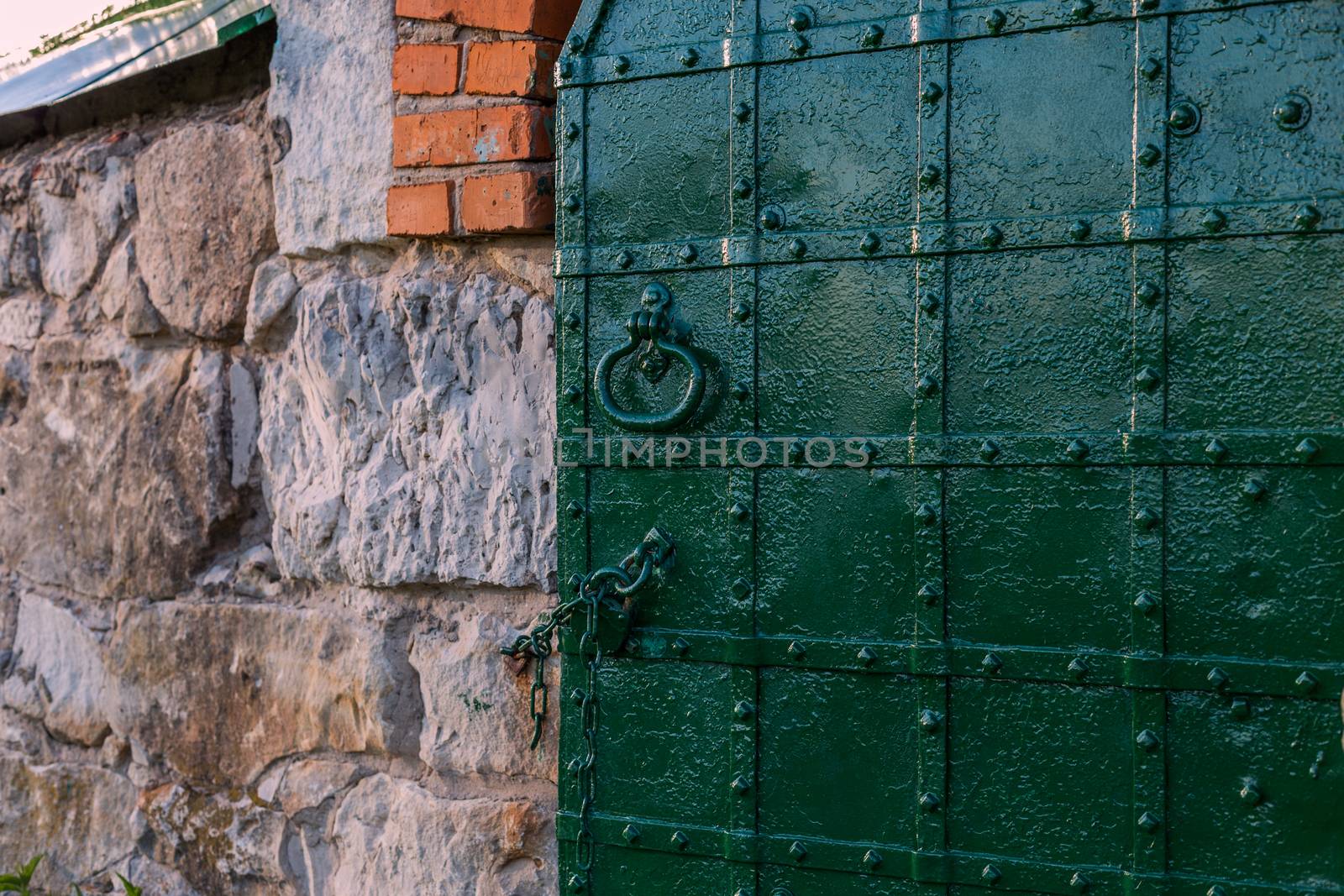 dark green riveted door background with selective focus