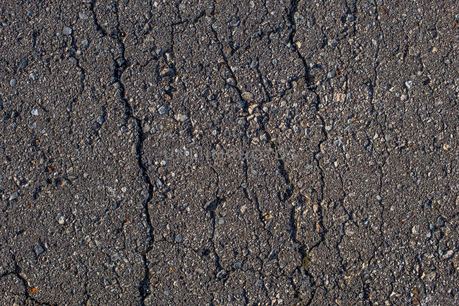 cracked across flat asphalt texture with hard direct sunlight