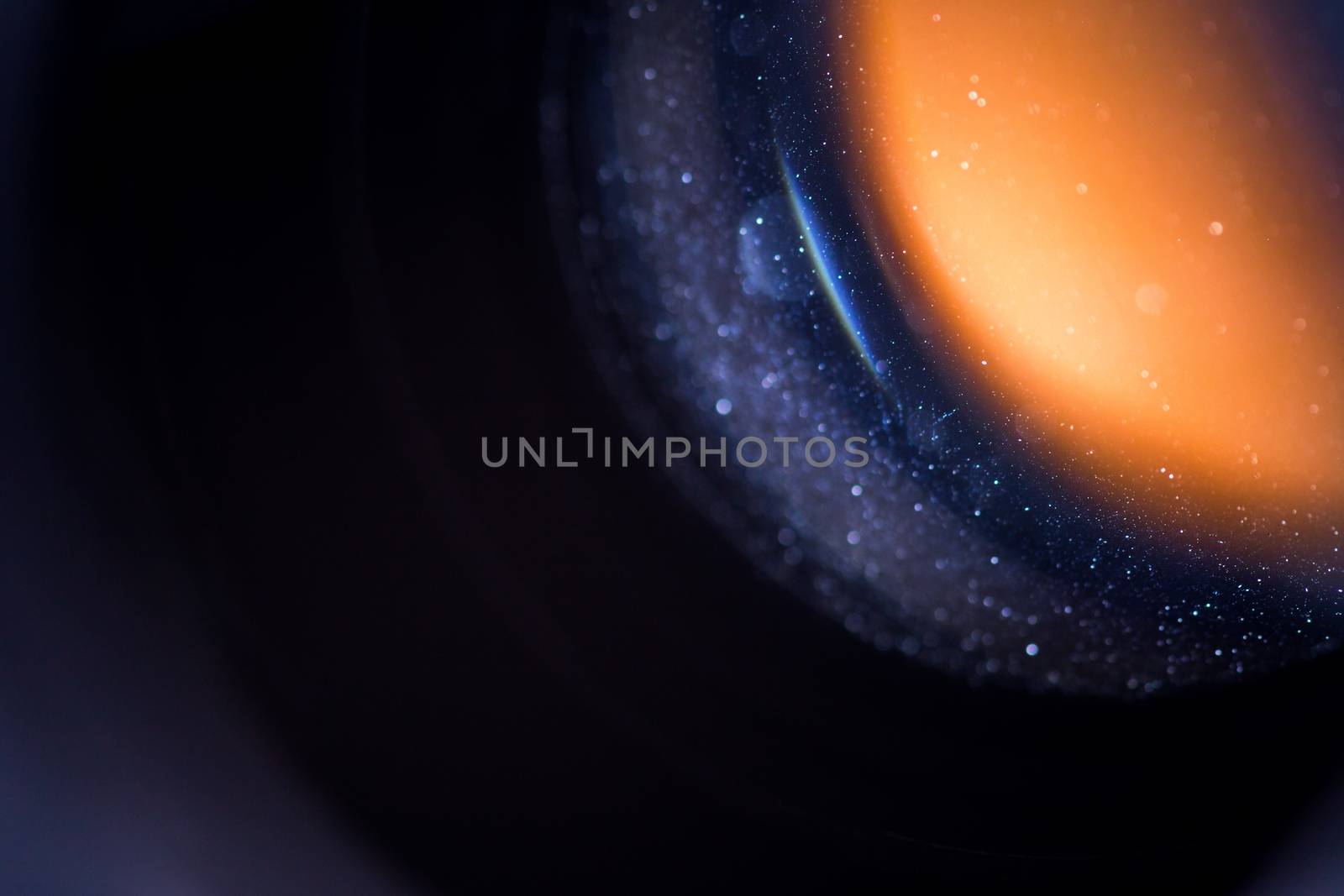 Dust inside lens dark macro shot with selective focus.
