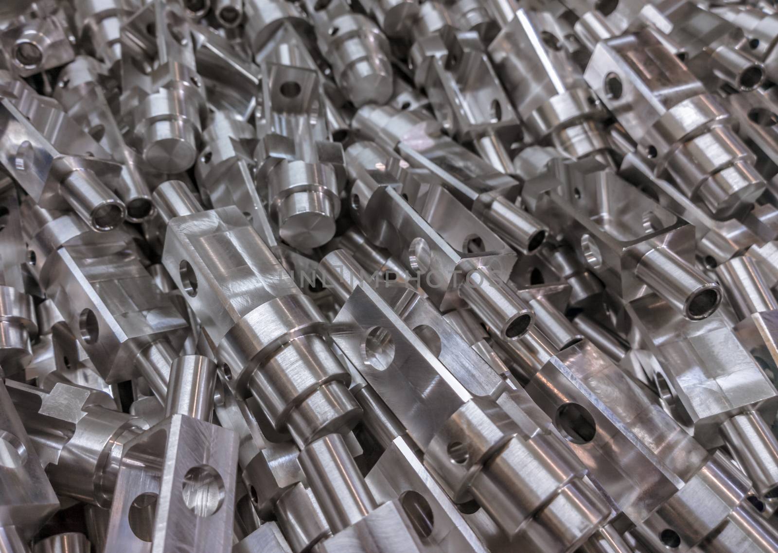 Shiny aluminium cnc machined parts background with selective focus close up technique.