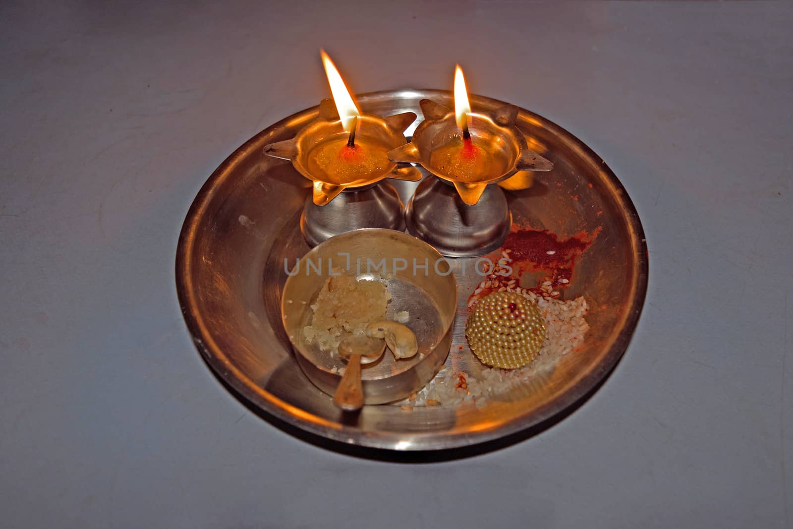 Isolated image of Indian Puja thali with two lit lamps. by lalam