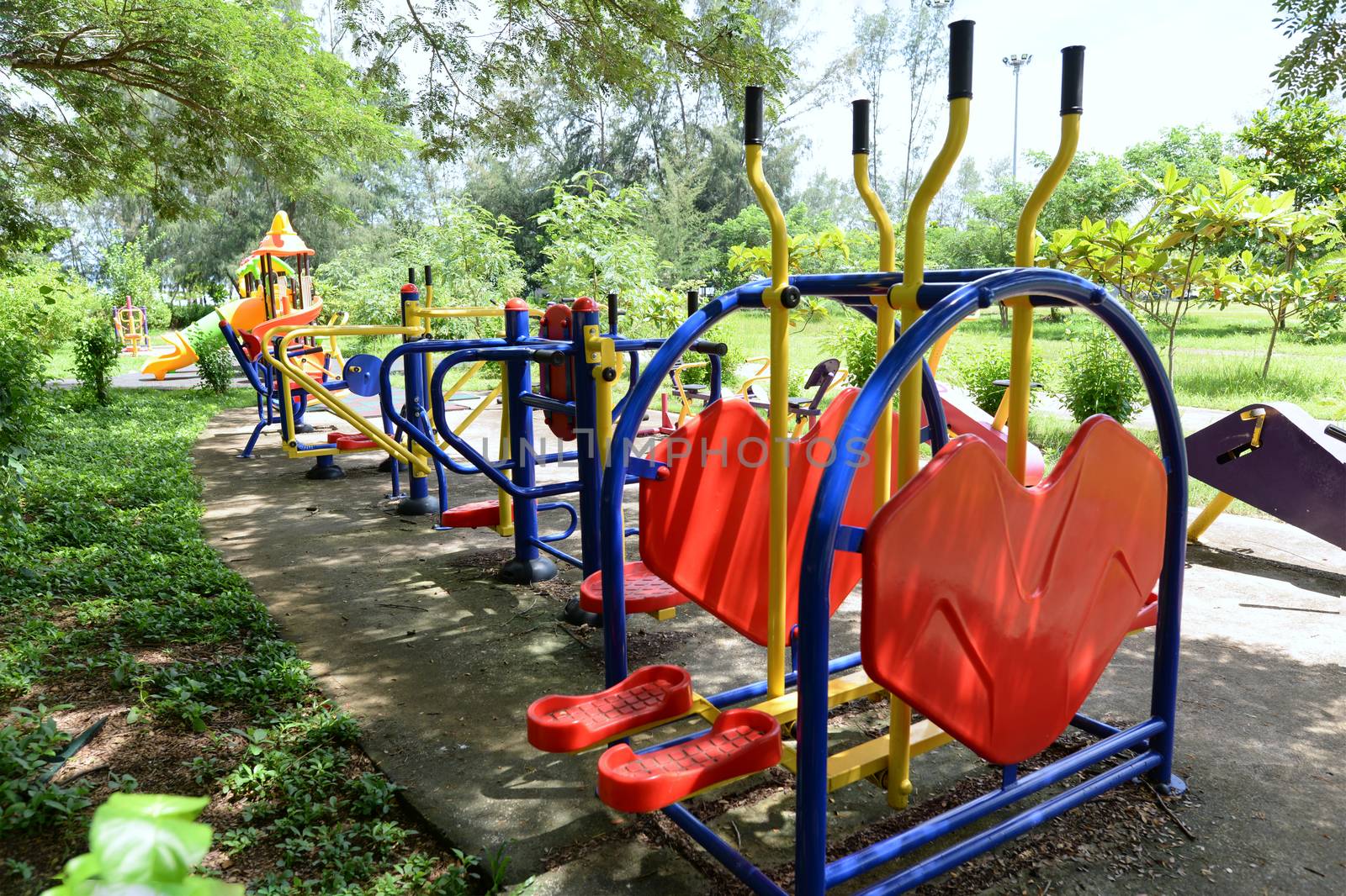 The colorful outdoor exercise machines in the park by hellogiant