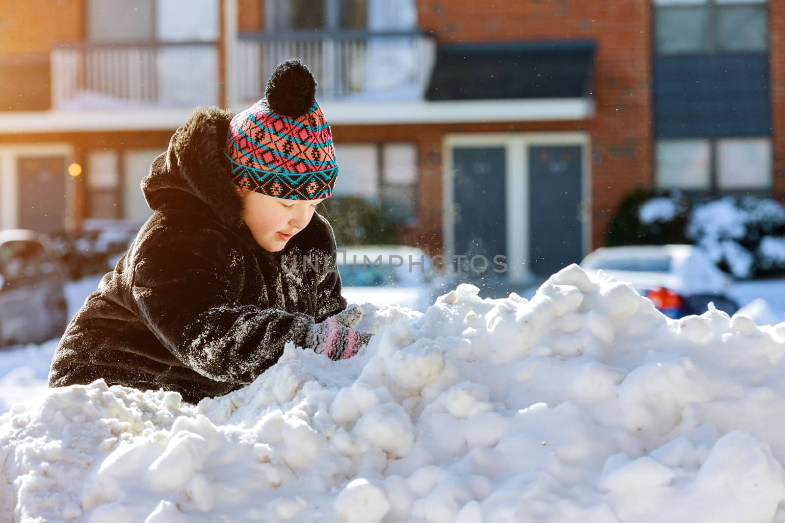 Little girl children play outdoors on snowy winter day in snow