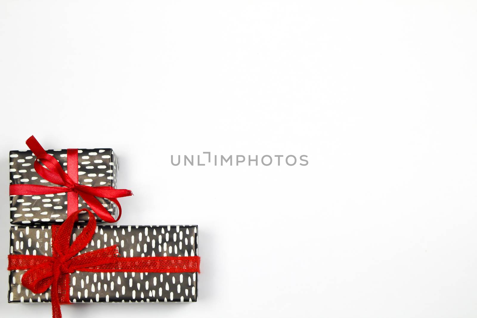 Gifts wrapped with beautiful paper and red bows on white background