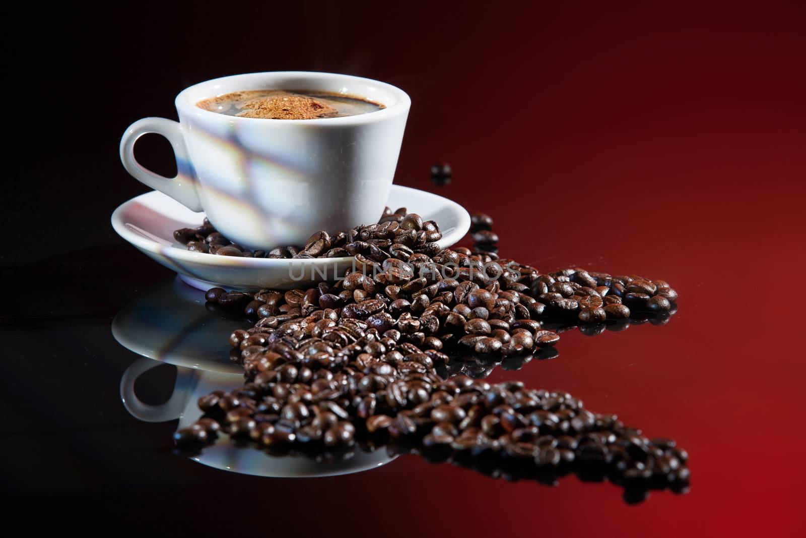 Cup of coffee and beans on a glass background