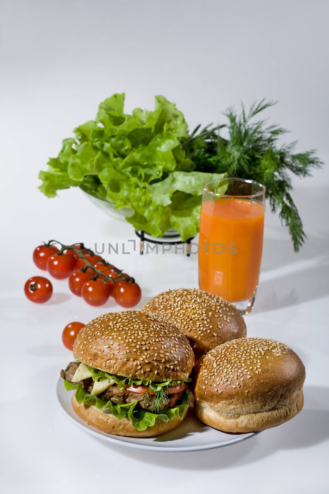 Hamburgers, greenery, tomatoes and juice