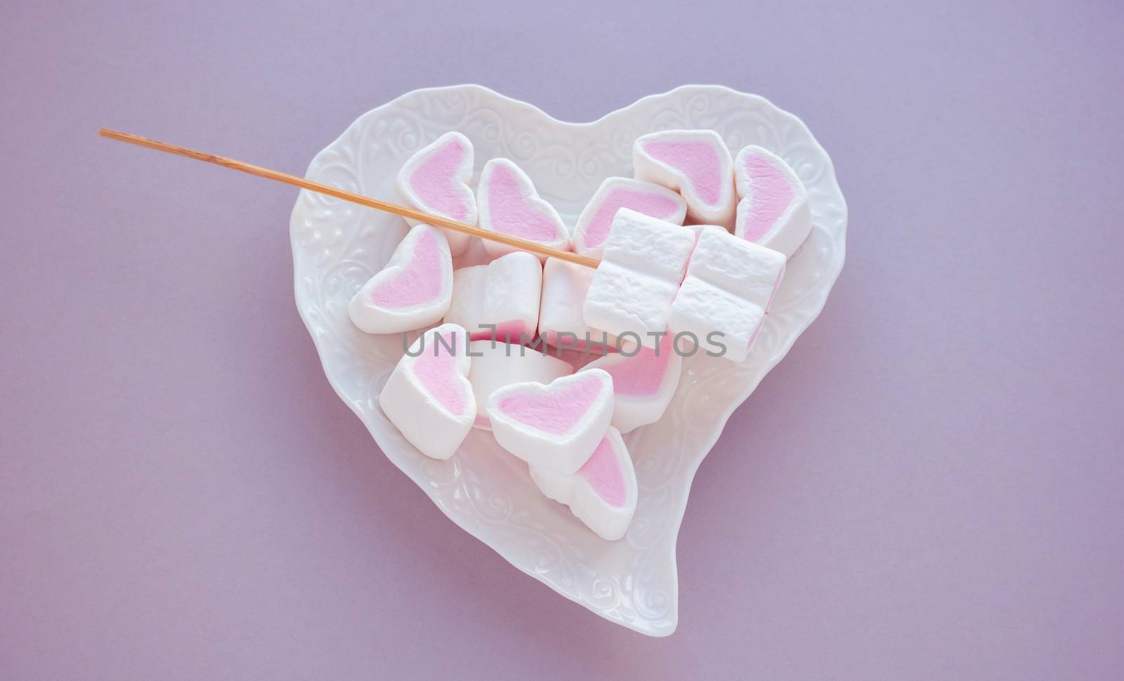 Heart-shaped marshmallow on a white plate on a pink background. The concept of mother's Day, Valentine's Day by lapushka62